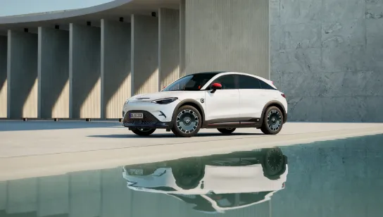 Ein weißer smart #3 steht zwischen einer Wasserfläche und einem Betonbogen.