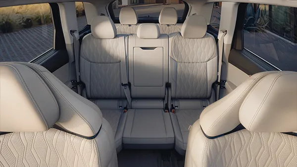 Innenraum des Audi Q7 mit sieben beigen Ledersitzen und sichtbaren Sicherheitsgurten.