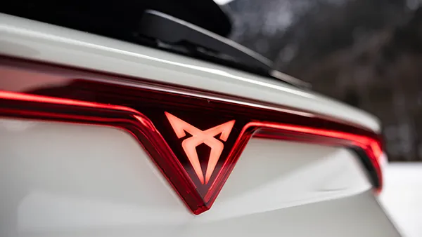 Leuchtendes CUPRA Logo am Heck eines weißen CUPRA Leon Sportstourer