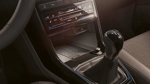 Mittelkonsole eines VW T-Cross mit manuellem Schalthebel und Bedienelementen.