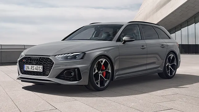 Seitenansicht eines grauen Audi RS4 Kombis auf gepflastertem Platz vor einem modernen Glasgebäude