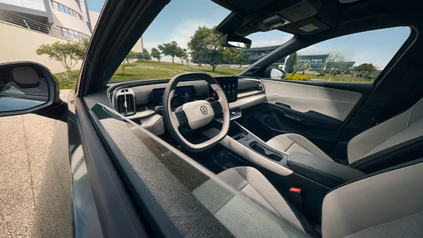 Das Cockpit eines VW ID. Cross mit digitalem Kombiinstrument, mittig platziertem Touchscreen und zweifarbigem Lenkrad in modernem Interieur.