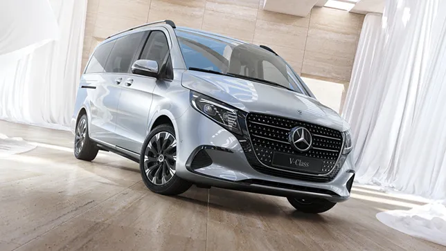 ine silberne Mercedes-Benz V-Klasse steht in einem hellen, modernen Raum mit hellen Fliesen und weißen Vorhängen.